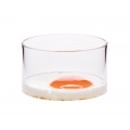 Huevo frito con el lado soleado hacia arriba en un innovador molde de vidrio transparente sobre blanco.