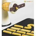 Fabricante de pasta extruyendo pasta fresca sobre una estera negra.