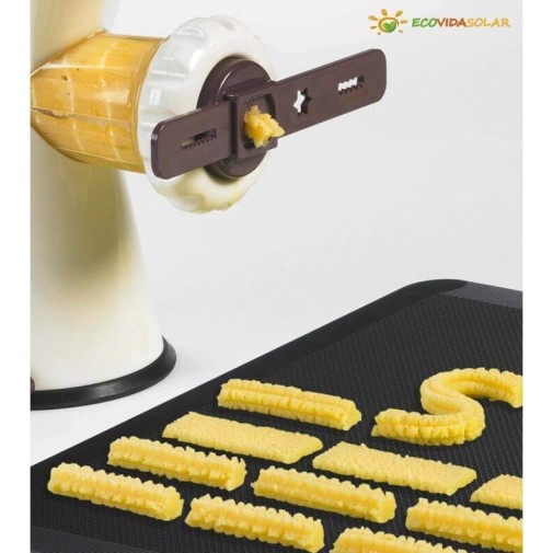 Fabricante de pasta extruyendo pasta fresca sobre una estera negra.