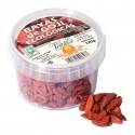 Un contenedor Vegetalia de bayas de goji orgánicas junto a una pequeña pila de bayas de goji sueltas.
