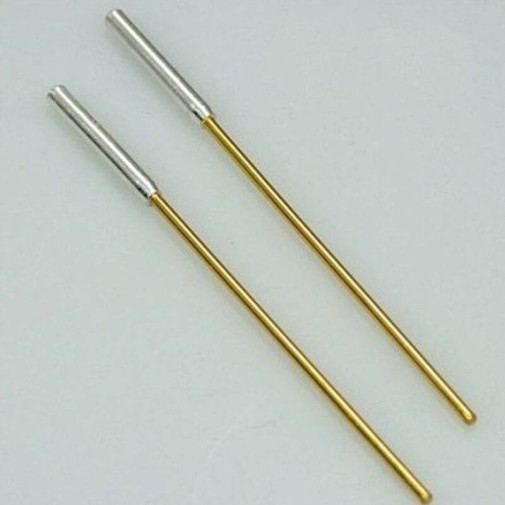 Dos electrodos de oro puro sobre fondo gris claro.