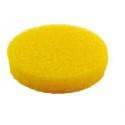 Una esponja de limpieza redonda, de color amarillo, con una piedra blanca sobre un fondo blanco.
