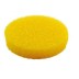 Una esponja de limpieza redonda, de color amarillo, con una piedra blanca sobre un fondo blanco.