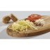 Patatas ralladas, rodajas de tomate y rábano picante adornan una tabla de acero inoxidable.
