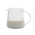Jarra Trendglas Jena medio llena de leche sobre un fondo blanco.
