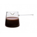 cazo Trendglas Jena de cristal con asa, llena de líquido oscuro sobre un fondo blanco.