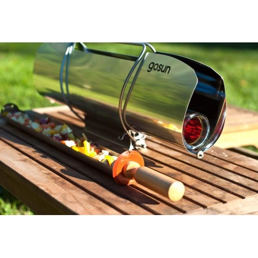 Cocinar recetas saludables con un horno solar GoSun Sport sobre una mesa de madera al aire libre.