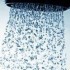 La lluvia de burbujas cae en cascada desde un cabezal de ducha montado en el techo.