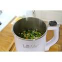 Licuadora abierta MioMat con vegetales picados, ideal para leches vegetales saludables, sobre encimera.