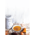 Sopa de calabaza en un bol, rodeada de rodajas de calabaza y una máquina de leches vegetales saludables.