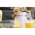 Exprimidor con sombrero de paja y gafas de sol, rodeado de vasos de leches vegetales saludables. Exprimidor con sombrero de paja y gafas de sol, rodeado de vasos de leches vegetales saludables.