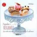 Exhibición de cupcakes veganos sobre soporte de cristal con diseño de portada de recetario.