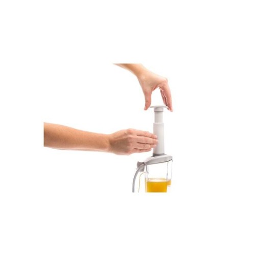 Manos operando un exprimidor manual, extrayendo sin esfuerzo jugo fresco en un vaso.