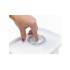 Botón presionando con la mano sobre una tapa hermética blanca de un recipiente de borosilicato. Botón presionando con la mano sobre una tapa hermética blanca de un recipiente de borosilicato.