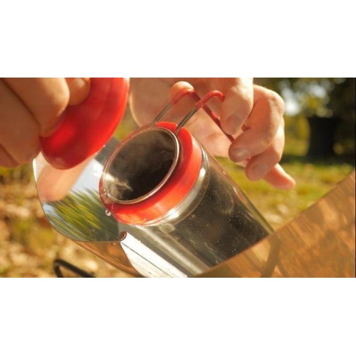 Persona vertiendo agua caliente de un hervidor solar al aire libre, como si estuviera usando un Gosun Brew, se ve vapor.