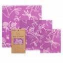 Juego de envoltorios de cera de abejas de color morado con motivos florales, un envoltorio ecológico en embalaje marrón.
