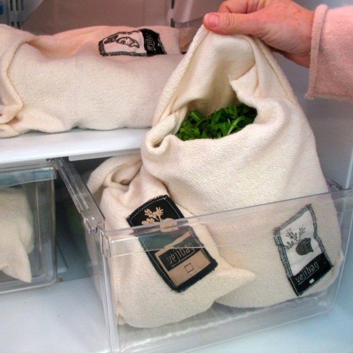 Colocación manual de verduras en una Vejibag en un cajón del refrigerador.
