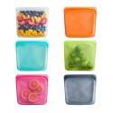 Seis bolsas de silicona reutilizables de colores, una con fruta, otra hermética con coles de Bruselas.
