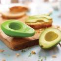 Medio aguacate sobre una tabla de cortar con rodajas, al lado de Aguacate Food Huggers.