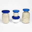 Tres frascos de vidrio con tapas azules, perfectos junto con utensilios de silicona para almacenar.