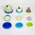 Frutas y verduras sobre platos de silicona de colores en una superficie blanca.