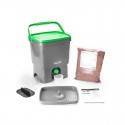 Contenedor de compostaje con accesorios y sustrato orgánico para reciclaje.