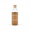 Botella de cristal con tapón de madera, envuelta en protección de corcho y bandas elásticas.