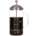Prensa francesa de vidrio de borosilicato llena de café preparado, marcada con líneas de medición.