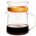 Cafetera de goteo de vidrio con soporte de bambú y café preparado.