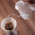 Hervidor de agua vertiendo agua sobre café filtrado.