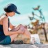 Mujer aplicándose una venda en la rodilla mientras está al aire libre.