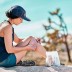Mujer aplicándose una venda en la rodilla mientras está al aire libre.