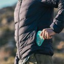 Hombre guardando una bolsa de silicona Stasher en su chaqueta.