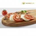 Tomates en rodajas y mozzarella sobre una tabla de madera con Börner-frutas cerca.