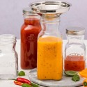 Botellas reutilizables de vidrio Kilner con boca ancha llenando con ayuda del embudo de acero inoxidable Kilner