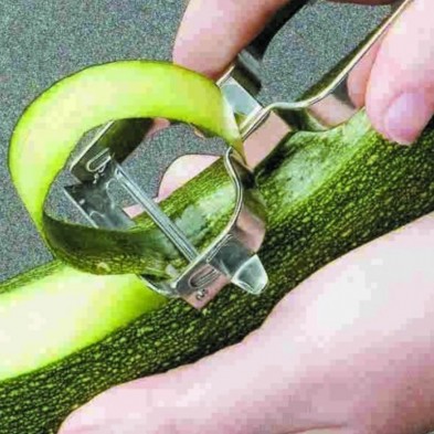Pelador listo Lacor de acero inoxidable cortando la piel de un calabacín