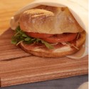 Bolsa de tela para sándwich Food Huggers con un bocata vegetal asomando la bolsa de tela