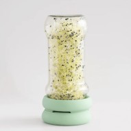 Bote largo de vidrio usando las Tapas germinadoras Sprout Food Huggers para germinar semillas.