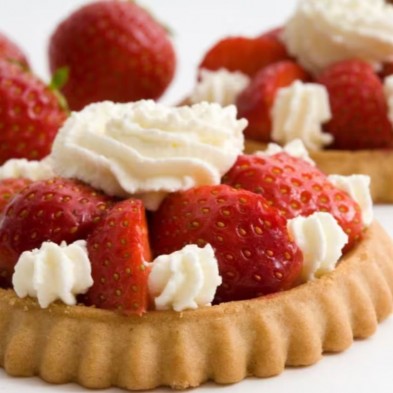 Una tarta de fresa, elaborada con moldes tartaletas hechas con el molde de silicona platino, está cubierta con crema batida Una tarta de fresa, elaborada con moldes tartaletas hechas con el molde de silicona platino, está cubierta con crema batida