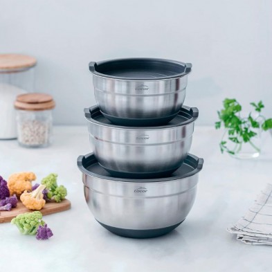 3 boles de acero inoxidable con sus tapaderas puestas y colocados uno encima de otros en una encimera de cocina