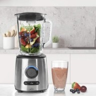 La Batidora Inox Lacor 69581 en una encimera de cocina con frutas en su interior y un batido ya preparado
