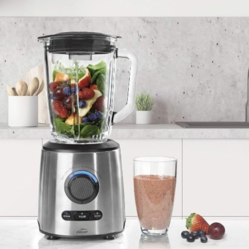 La Batidora Inox Lacor 69581 en una encimera de cocina con frutas en su interior y un batido ya preparado