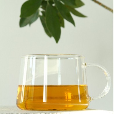 Taza de vidrio de borosilicato CONUM Trendglas Jena con una infusión en su interior.