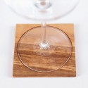 Copa de vino sobre posavasos de madera con motivos geométricos de la flor de la vida