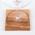 Copa de vino sobre posavasos de madera con motivos geométricos de la flor de la vida