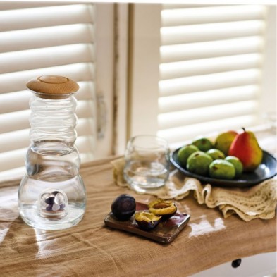 Jarra Cadus con agua en su interior y depósito de gemas con su tapón de pino y un vaso mythos de la colección de Nature's Design