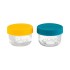 Dos pequeños frascos de vidrio con tapas de color amarillo y verde azulado sobre un fondo blanco.