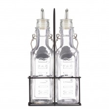 Dos botellas de vidrio transparente con picos vertedores en un soporte de metal negro de la marca KILNER