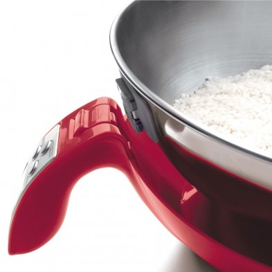 Primer plano de una balanza de cocina electrónica roja con un cuenco de arroz blanco encima.