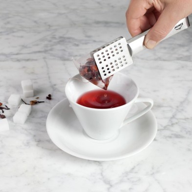 Pinza bolsitas té Lacor usándolas con una bolsita de té en una taza
